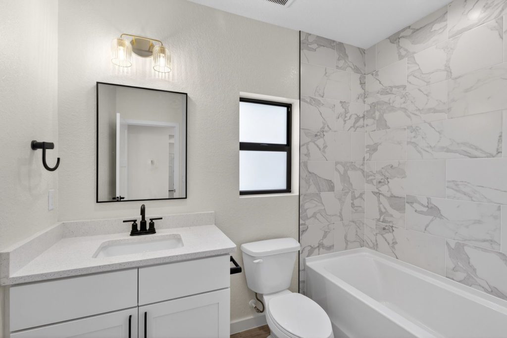 Guest bathroom with tub and marble-look surround