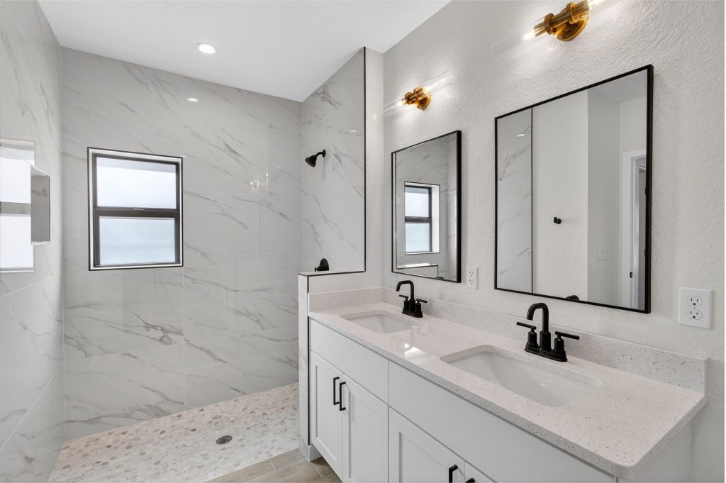 Primary bathroom with double vanity and marble-look walk-in shower